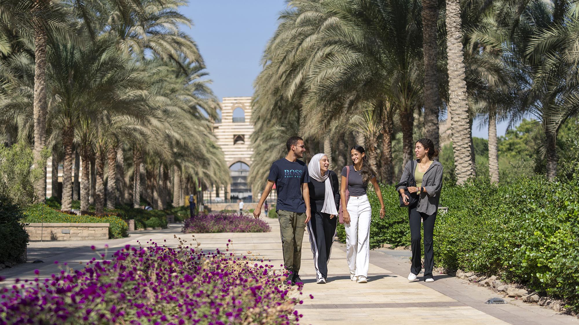 a group of students walking on campus smiling
