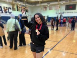 A girl holding a trophy on a basketball court