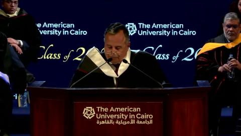 A man is standing on a podium and people are sitting behind him, text reads: the American University in Cairo
