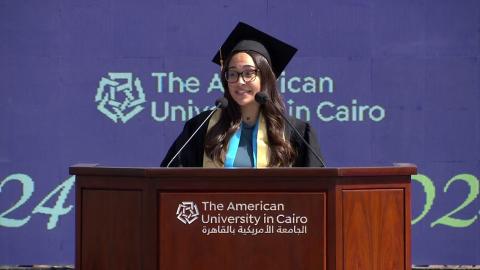 A girl is standing on a podium, text reads: the American University in Cairo