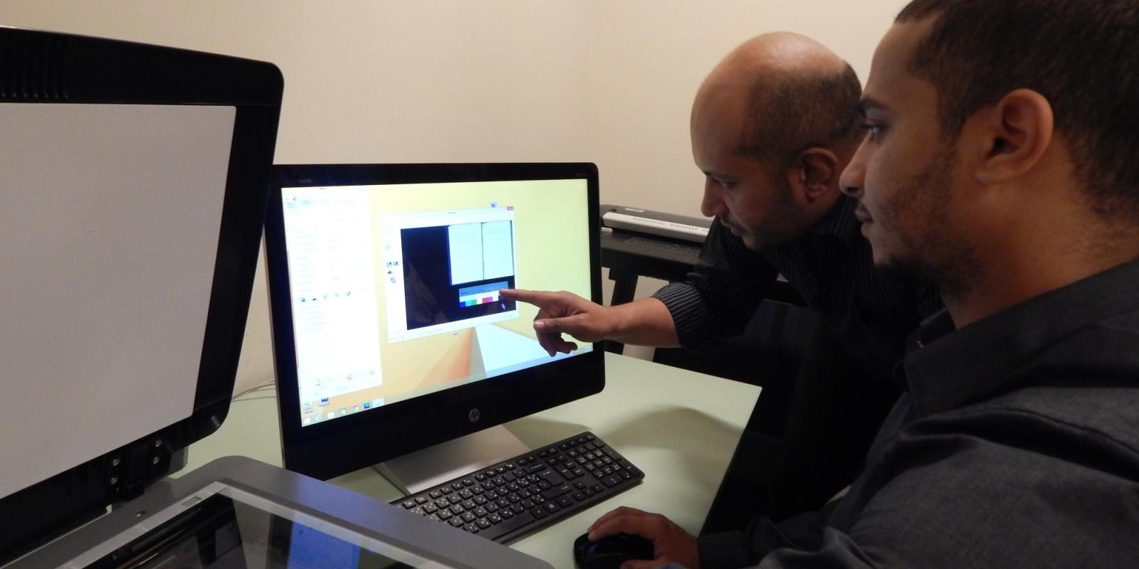 Mohamed Abdel Rehim and Mohammed Saleh scan books for AUC Library's new project with Arabic Collections Online