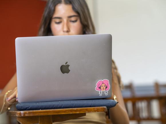 Girl sitting in class on her laptop