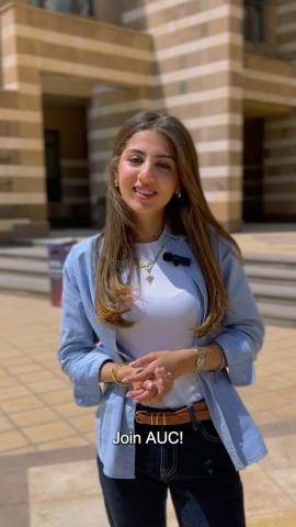 A young female is standing and smiling. Text: Join AUC!