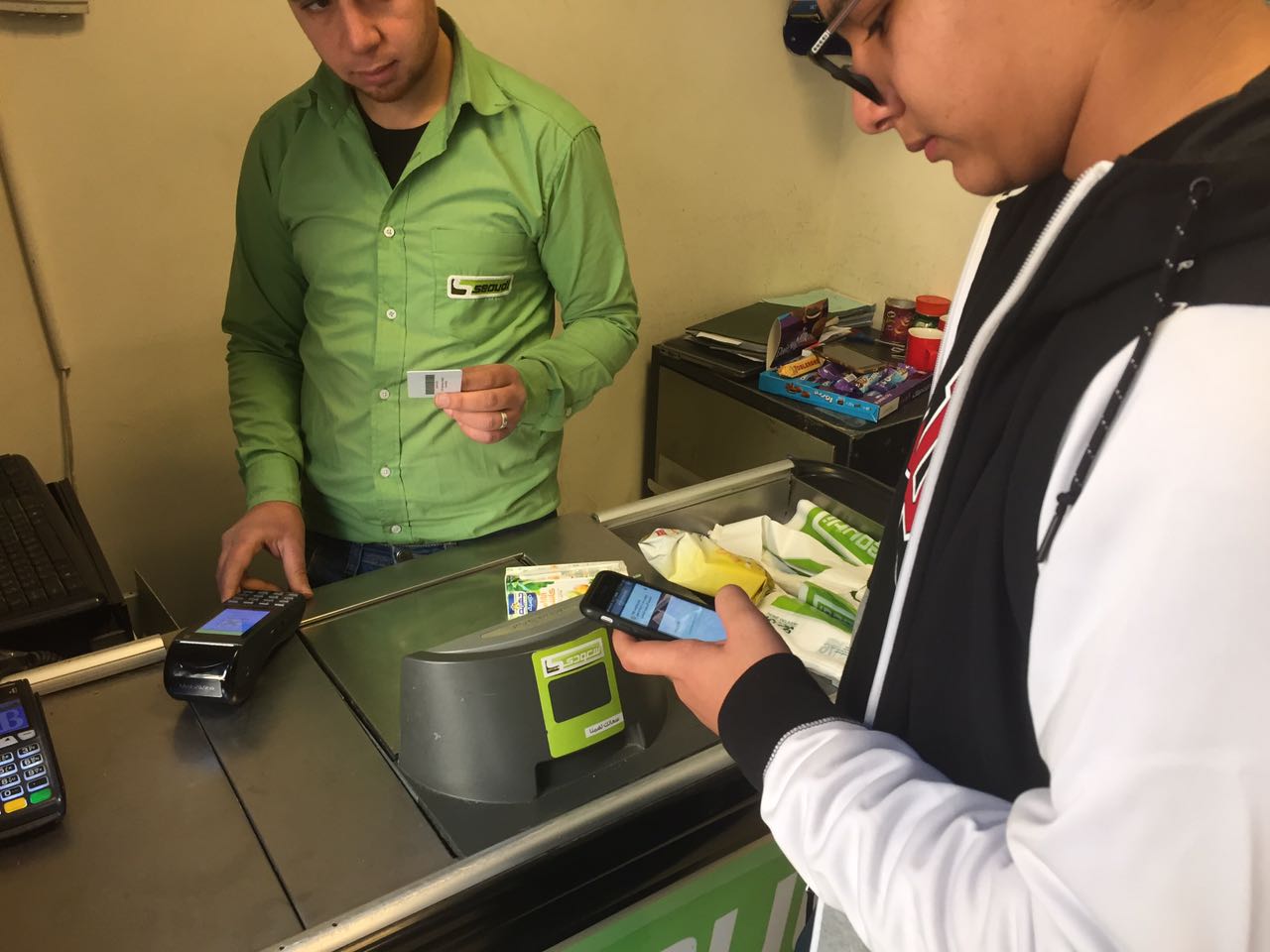 a student using his ID to buy something from a cashier across the counter