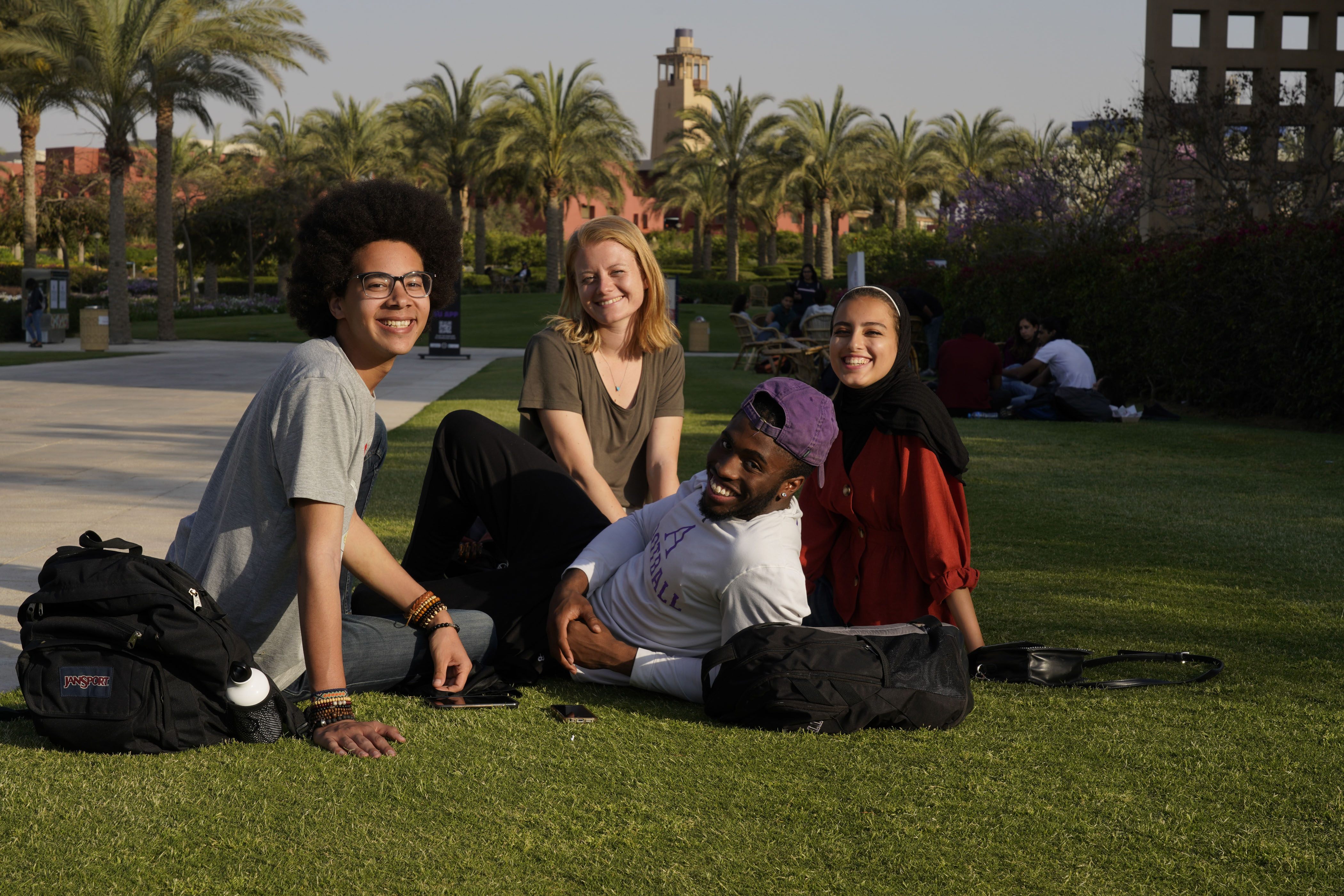 AUC international students sitting in the campus gardens. 