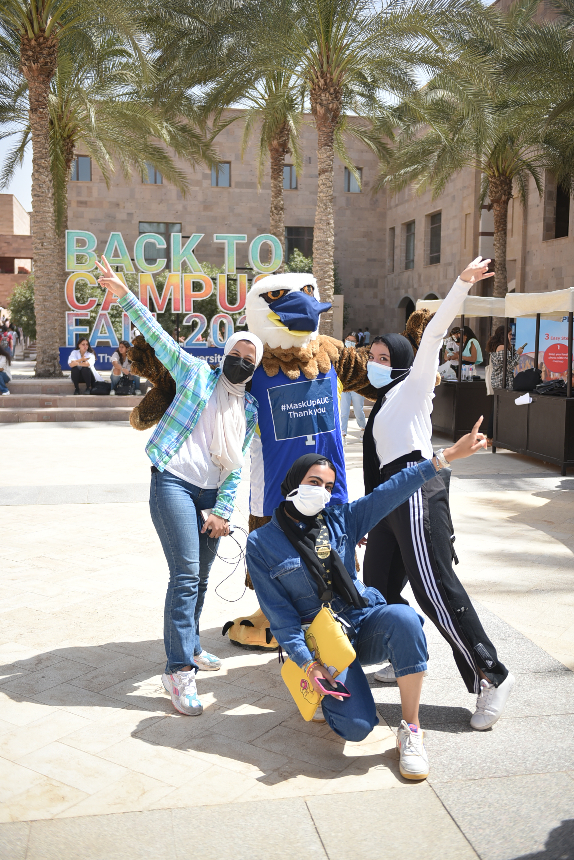 students posing with auc mascot