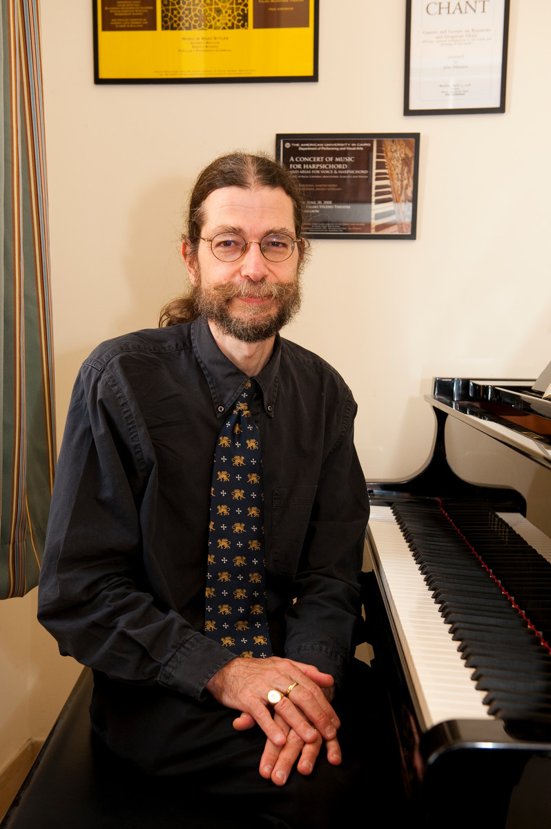 Bearded man sitting by the piano