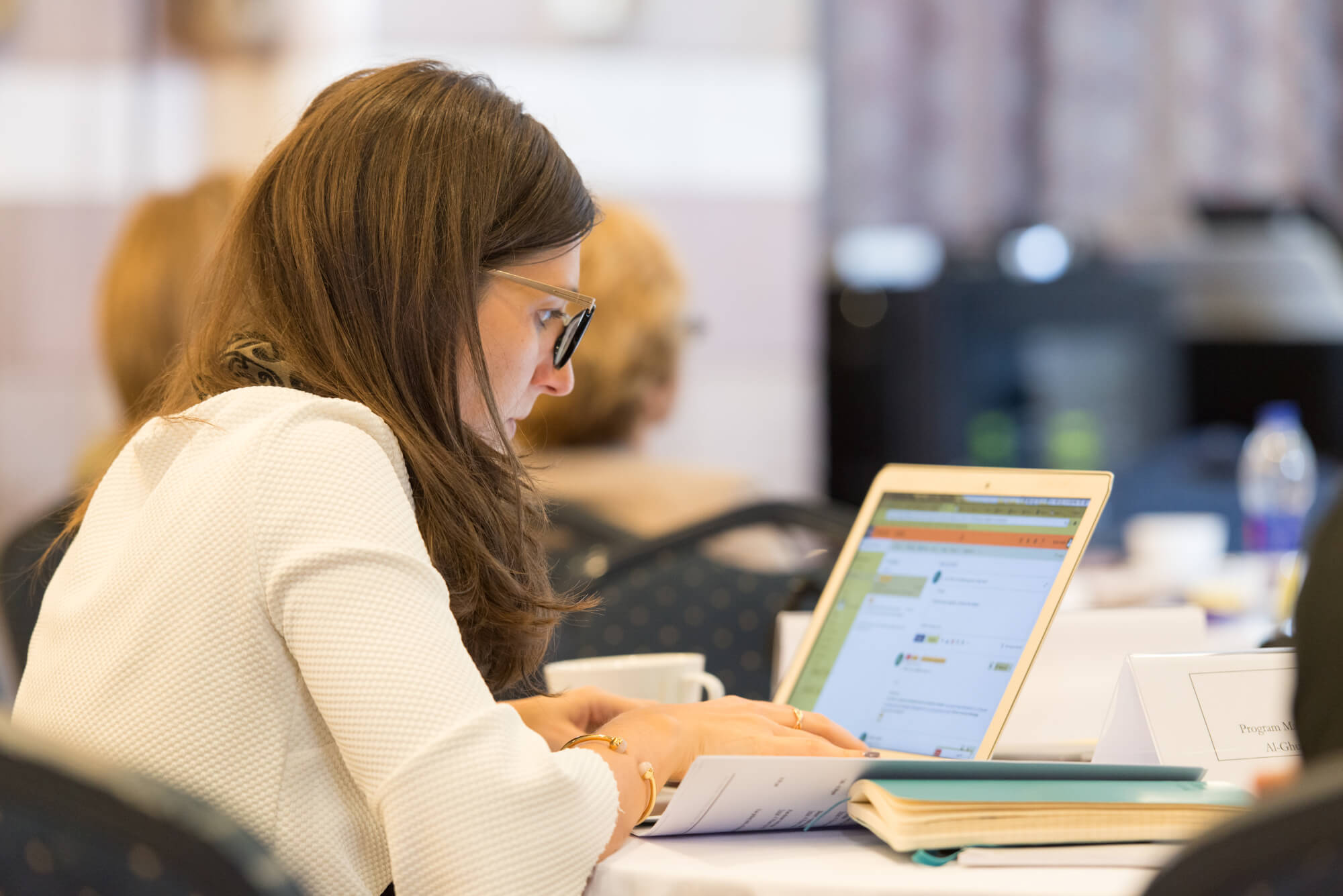 Woman writing in front of her laptop