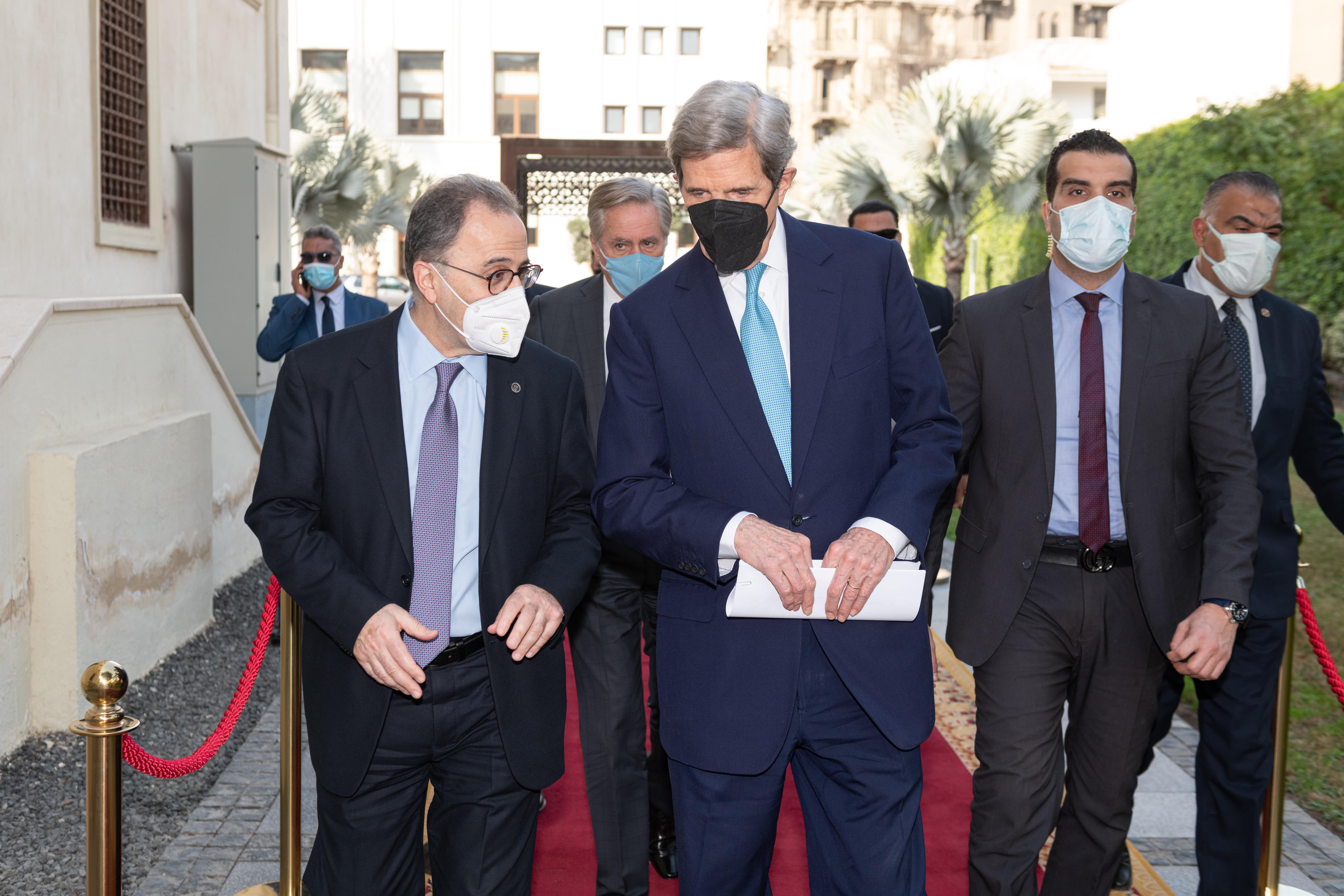 AUC President Ahmad Dallal and U.S. Special Presidential Envoy for Climate John Kerry walking together with people