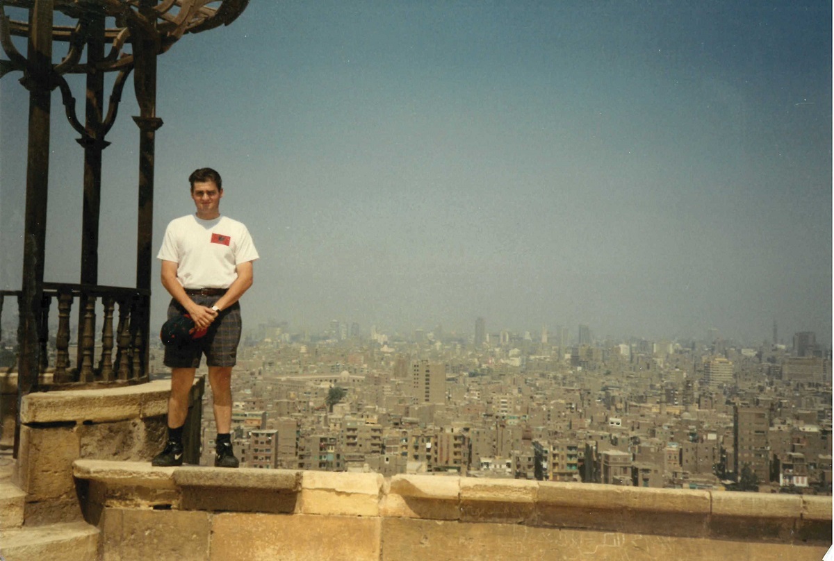 a man dressed in a tshirt and shorts standing on top of a building