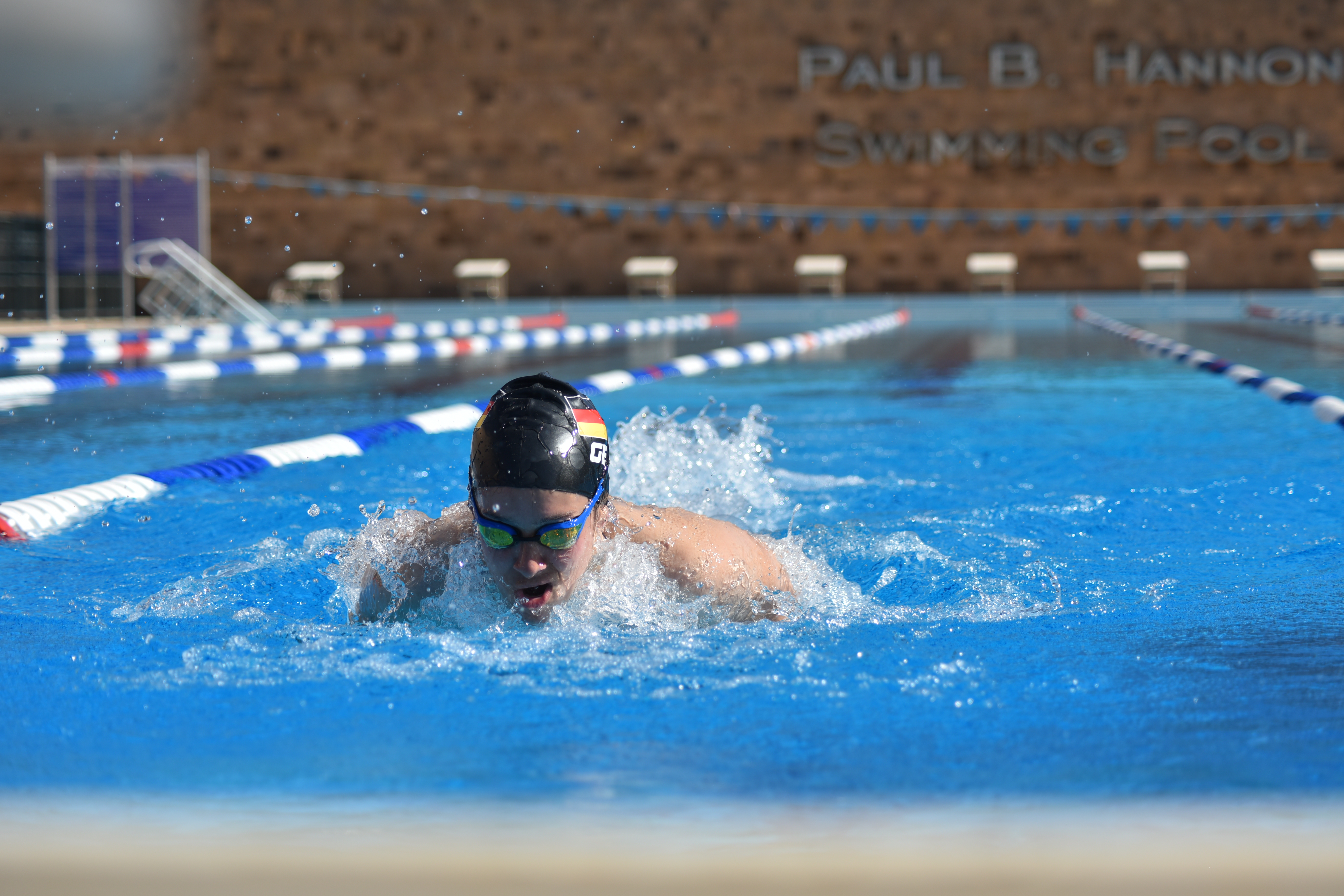 a male student swimming in the swimming pool