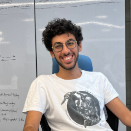 Boy with glasses sitting on a chair smiling