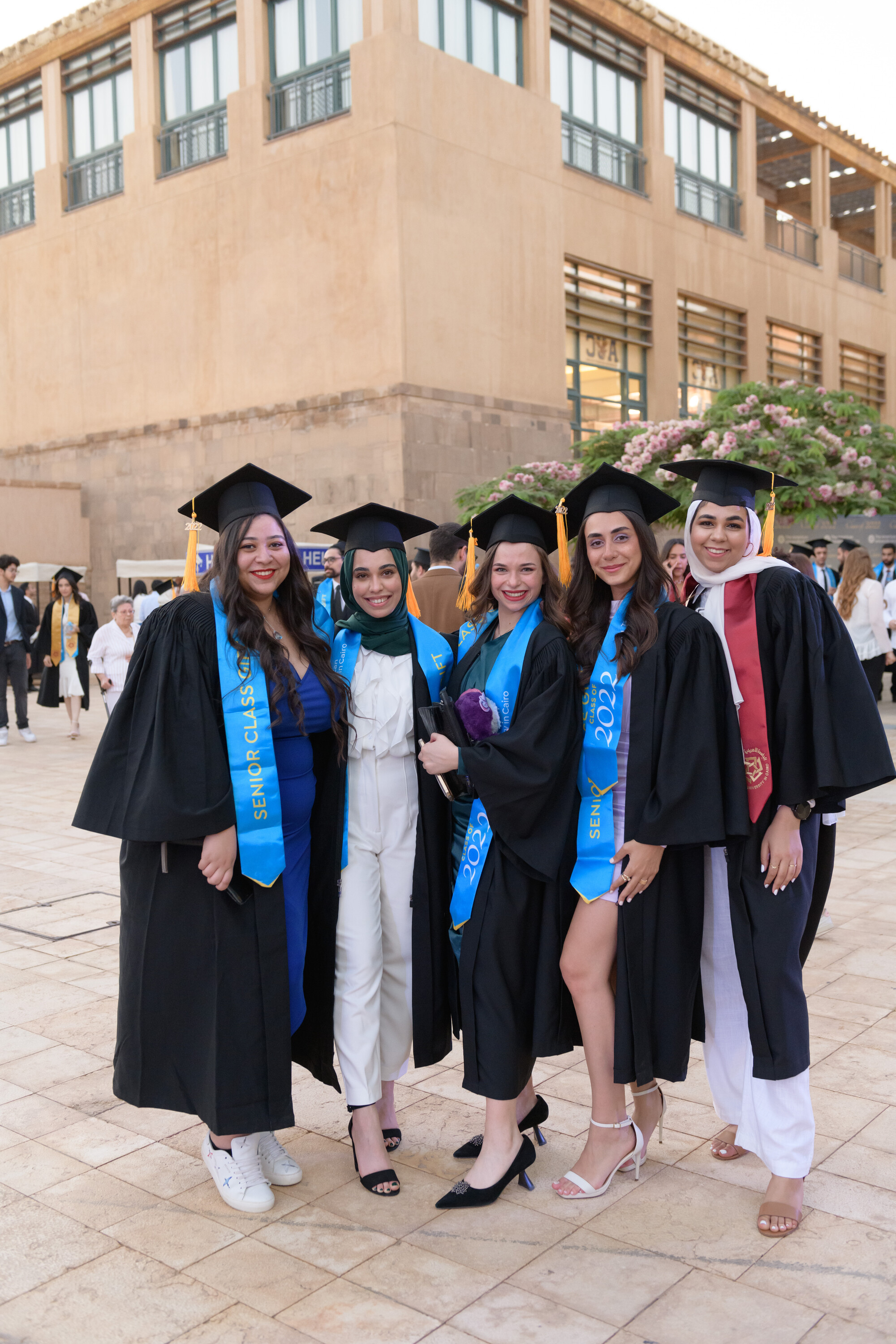 group of smiling girls with cap and gown
