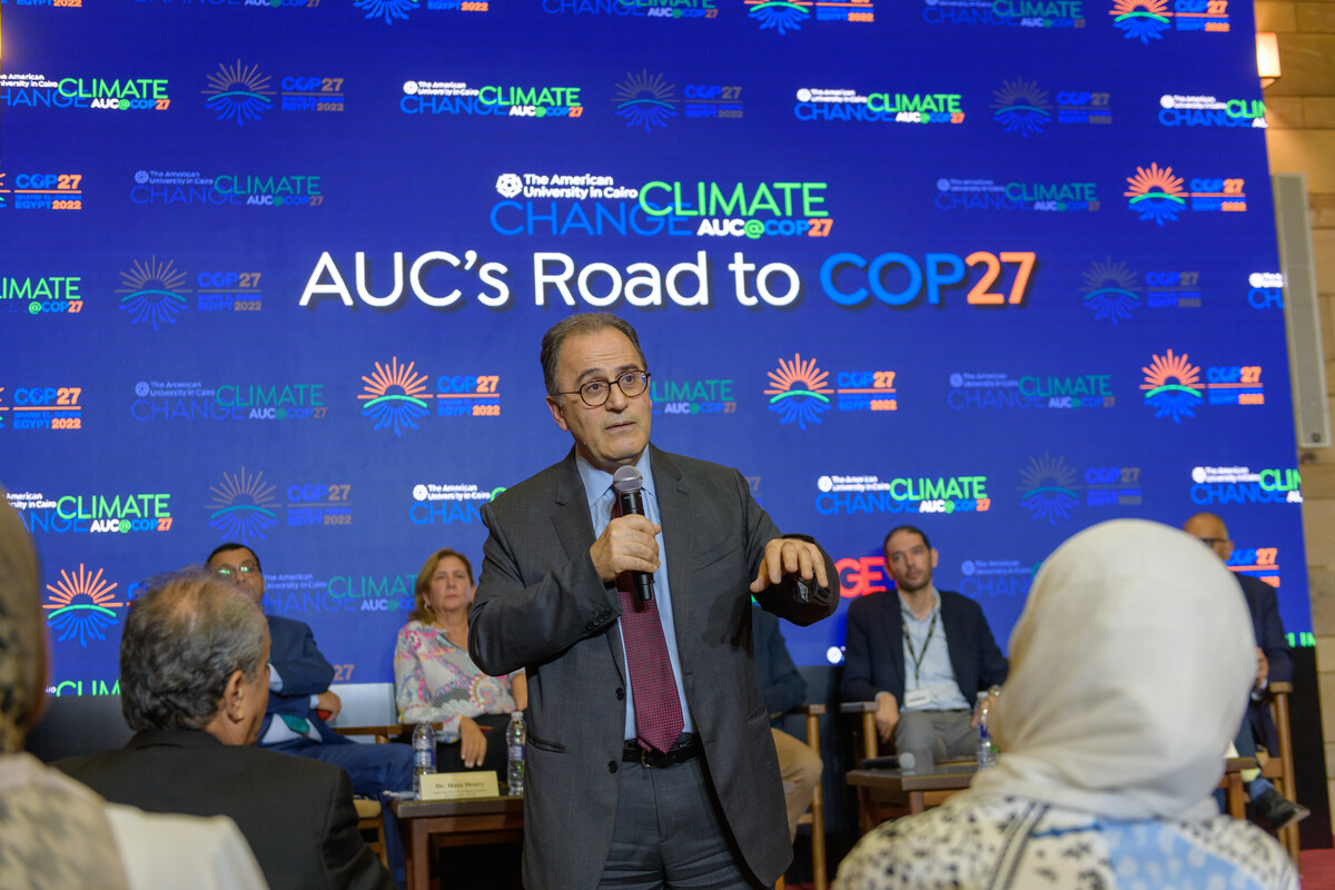 Man talking into a microphone to the audience AUC's Road to COP27
