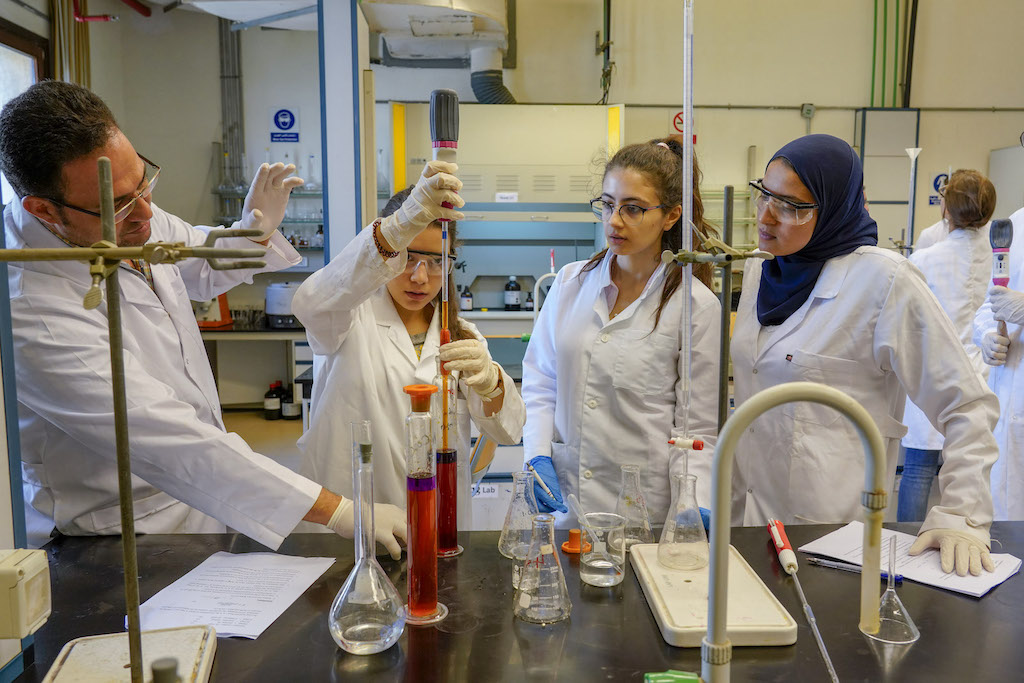 Female students in a lab with faculty