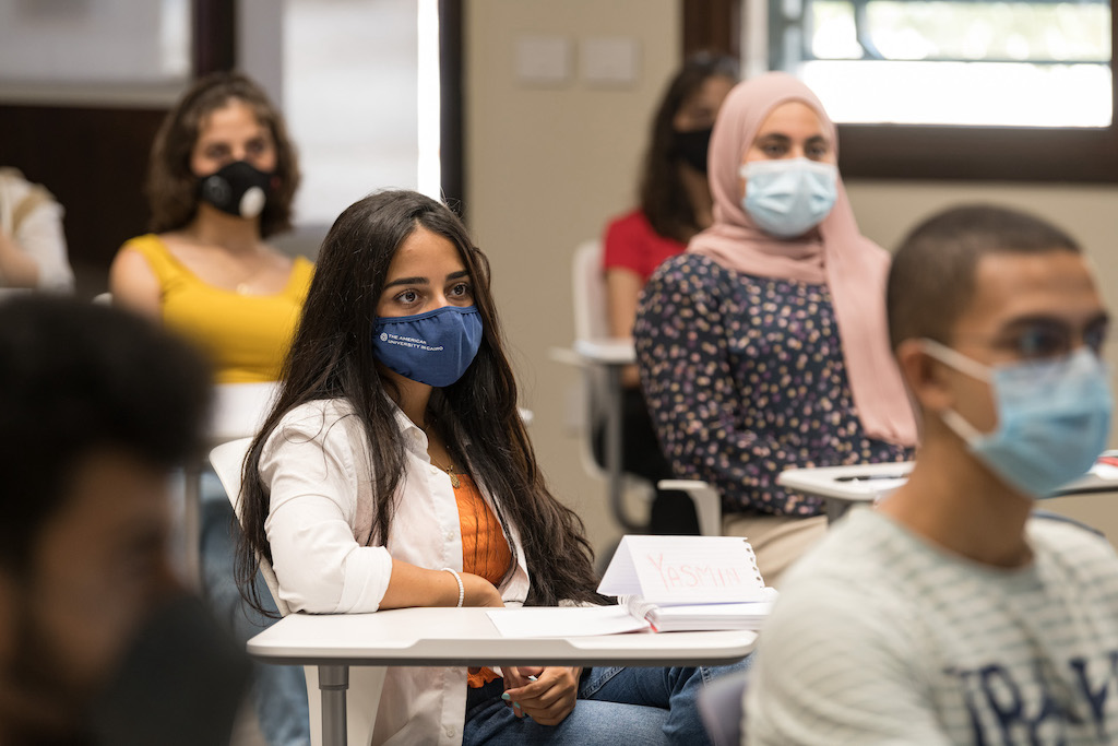 Female student in classroom wearing a blue mask