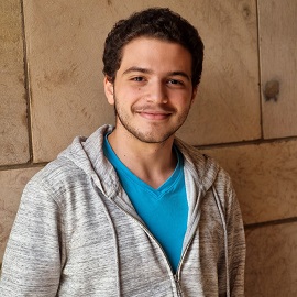 Boy smiling wearing a tshirt and jacket