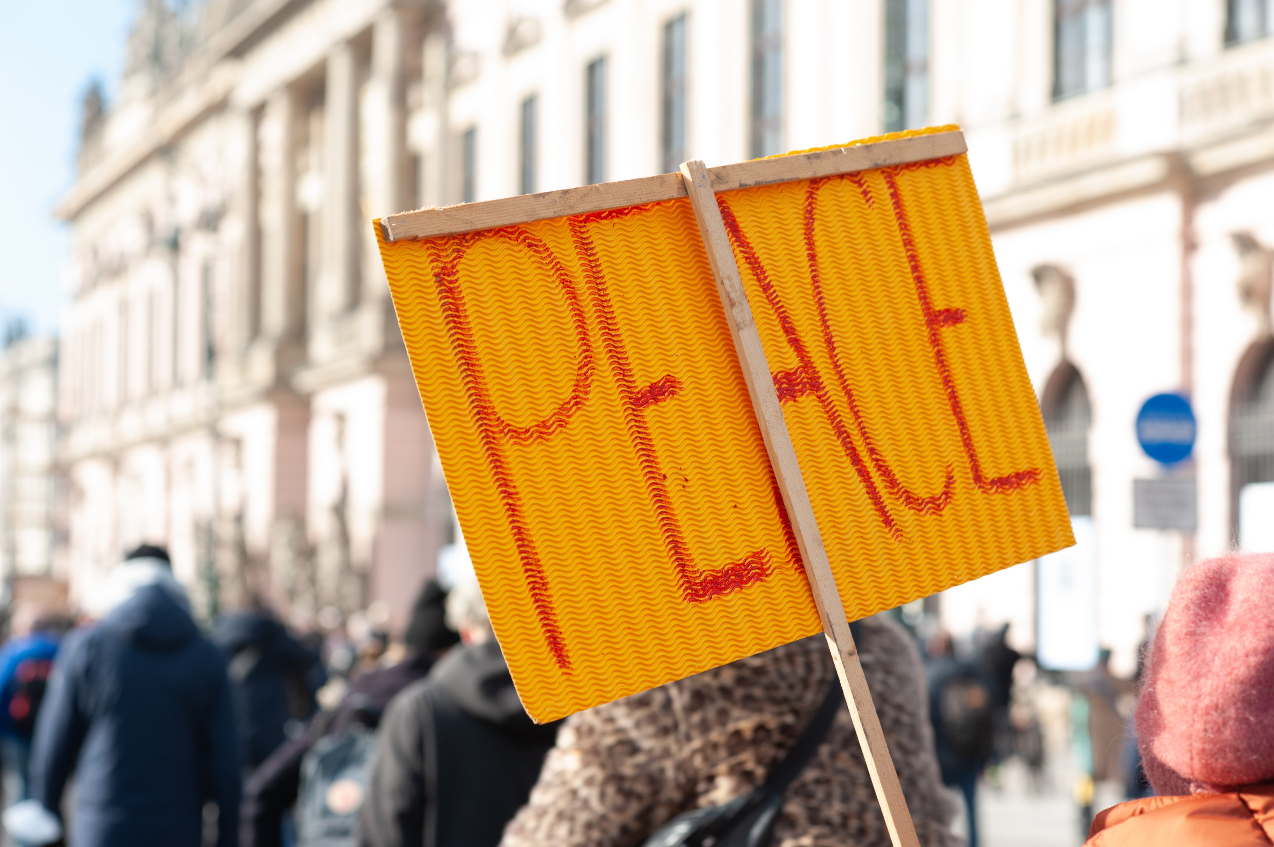 Peace written on a sign held up in a crowd