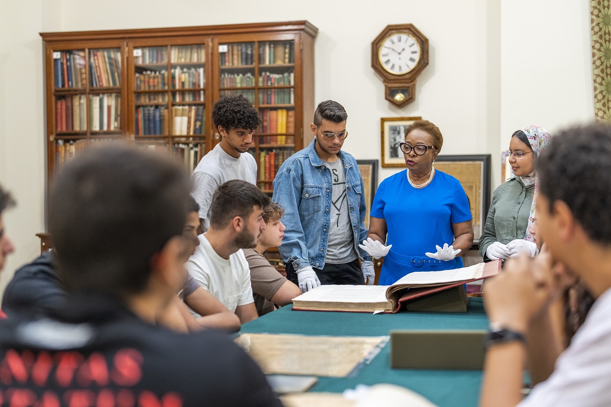 Professor talking to students in a library