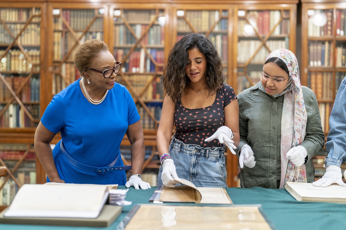 Professor and students looking at old books