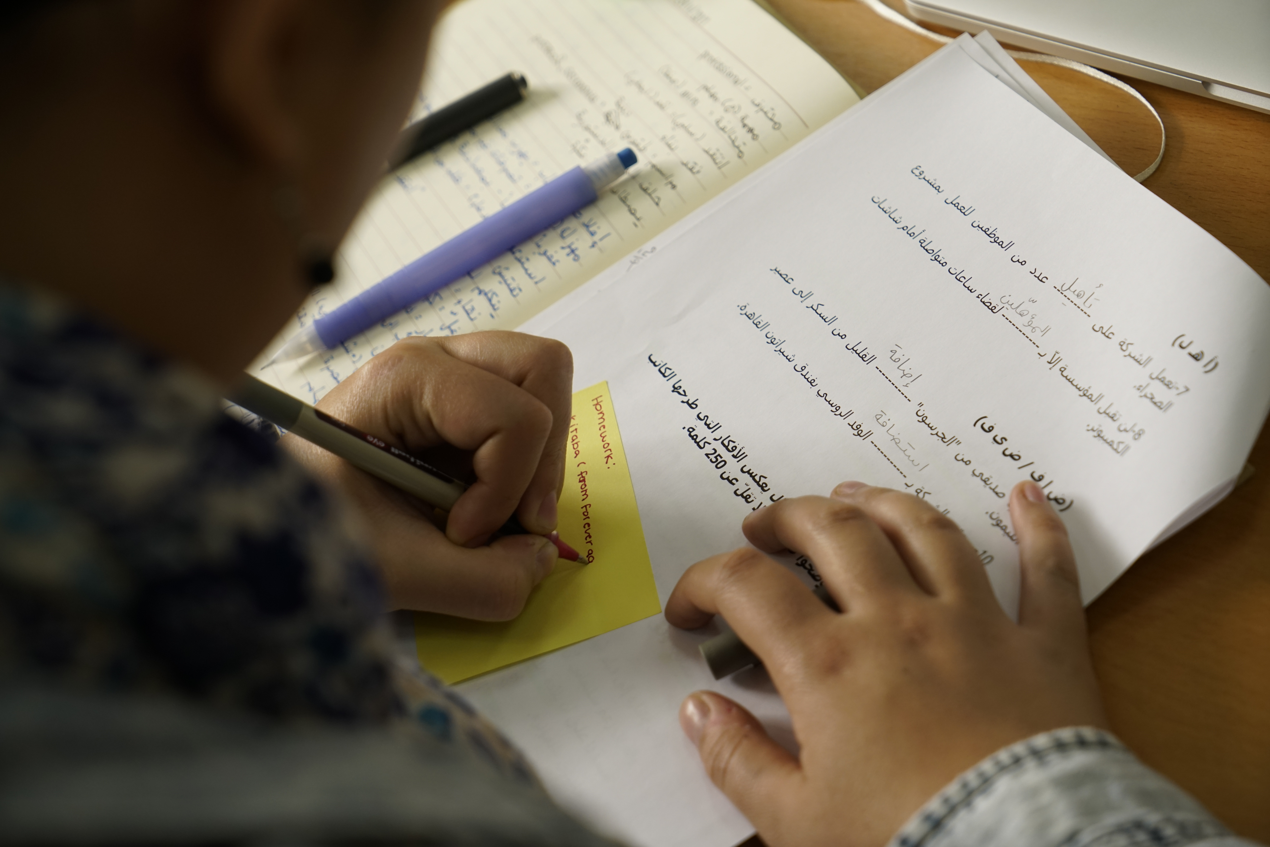 close of up of student writing Arabic and taking notes