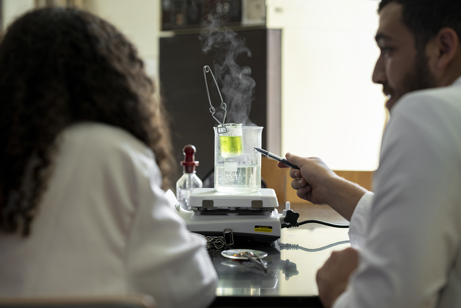 students working in lab with chemicals in white coats