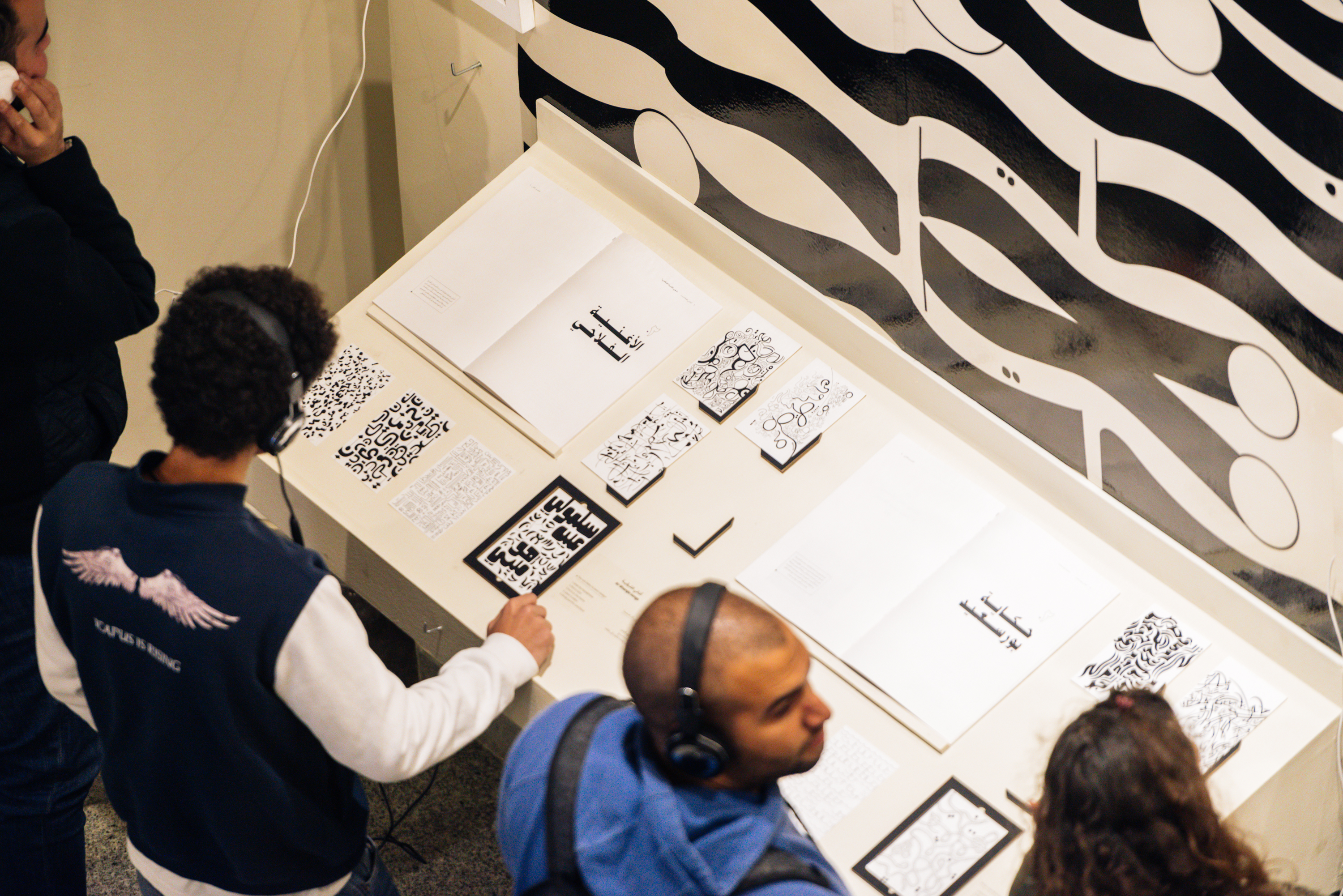 students in exhibition in art gallery with headphone hearing the information