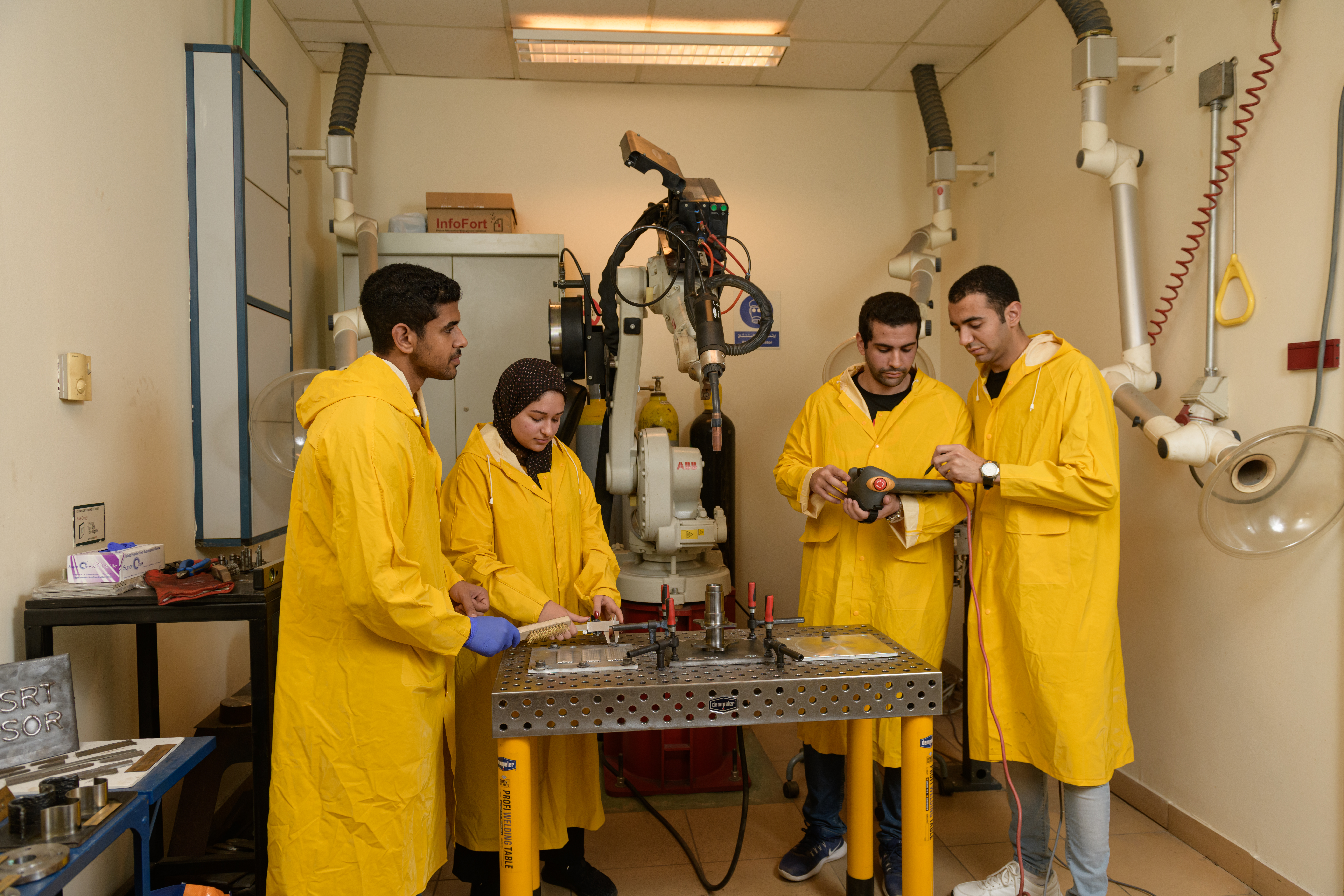 students wearing orange coats working in mechanical engineering labs