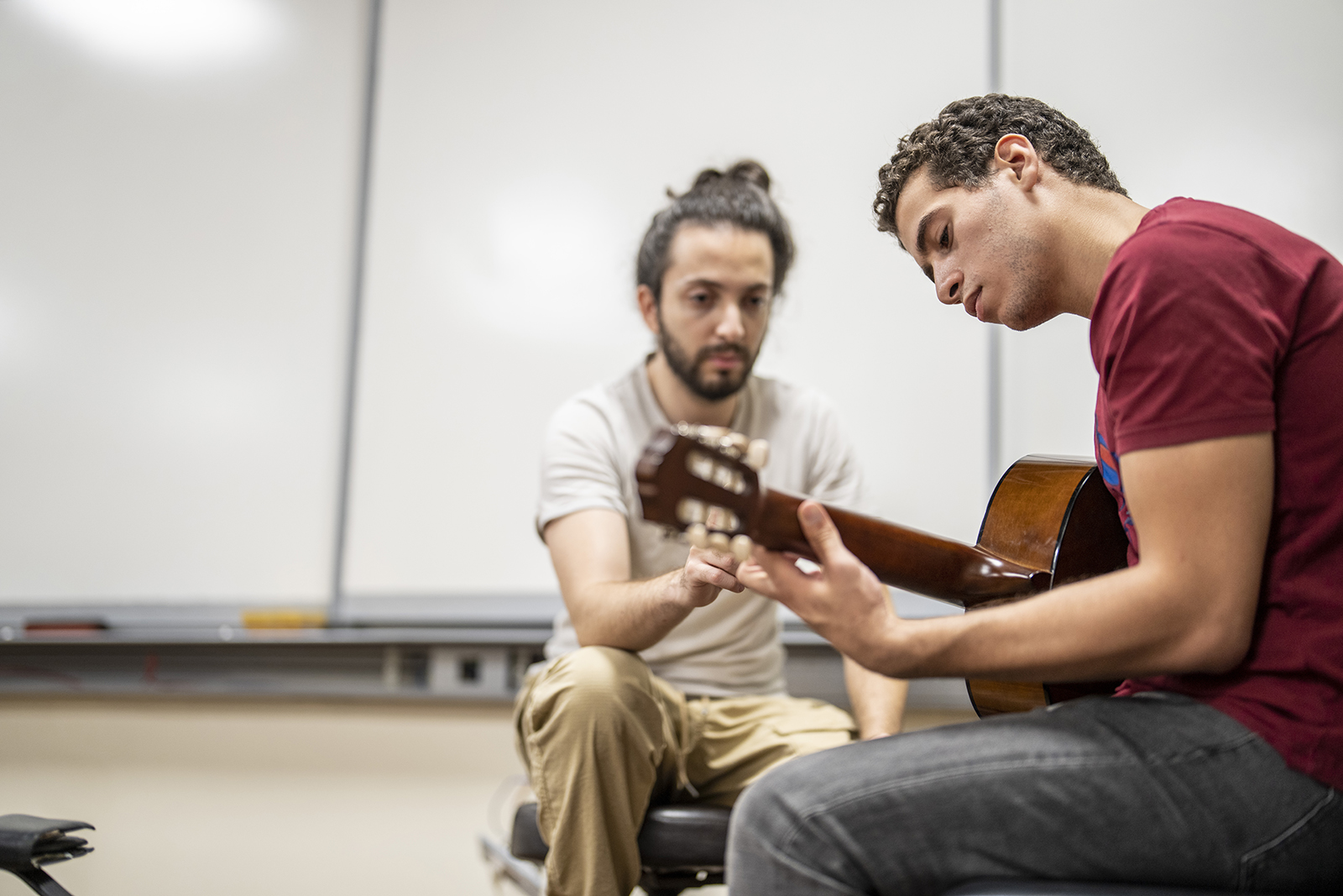 professor teaching student the guitar