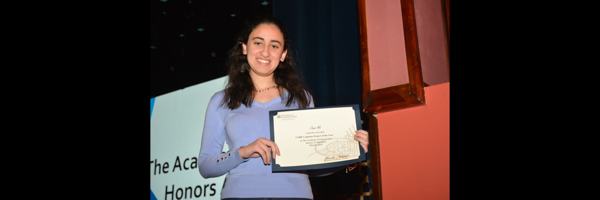 A picture of a student with their certificate of excellence 