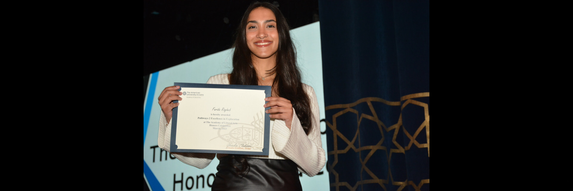 A picture of a student with their certificate of excellence 