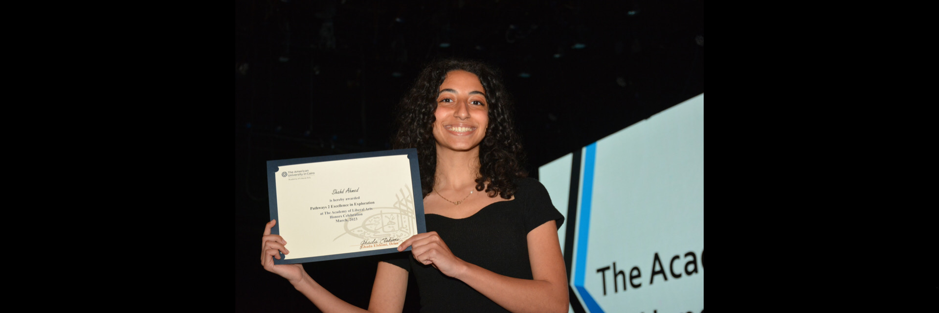 A picture of a student with their certificate of excellence 