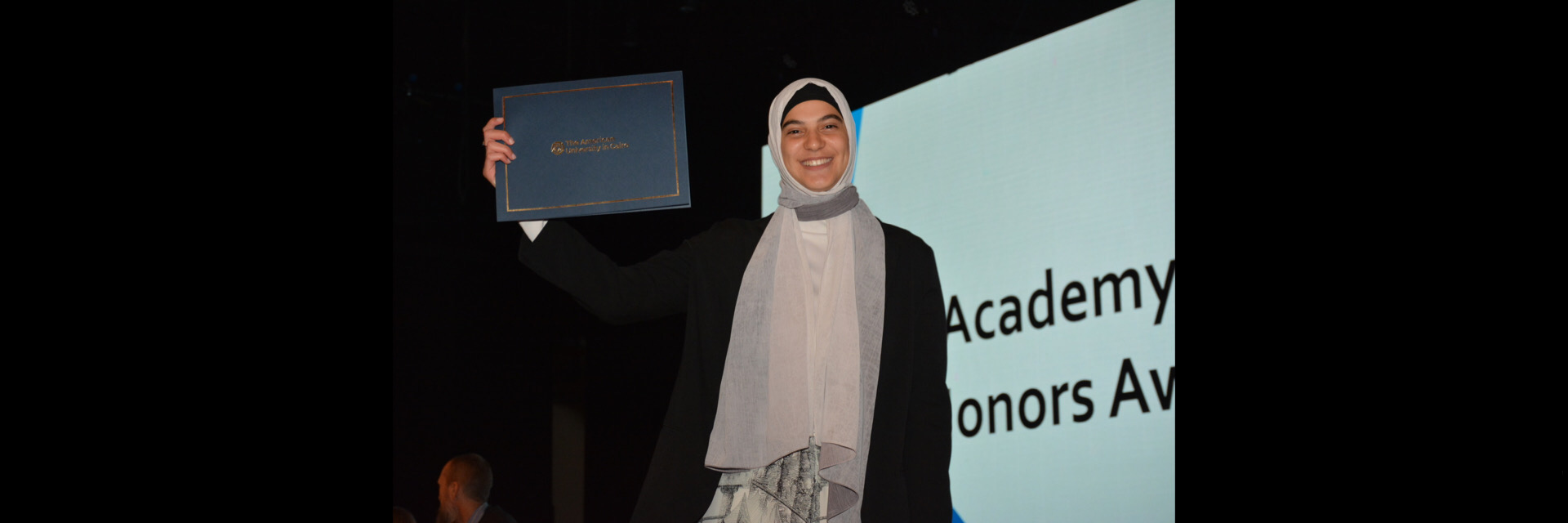 A picture of a student with their certificate of excellence 