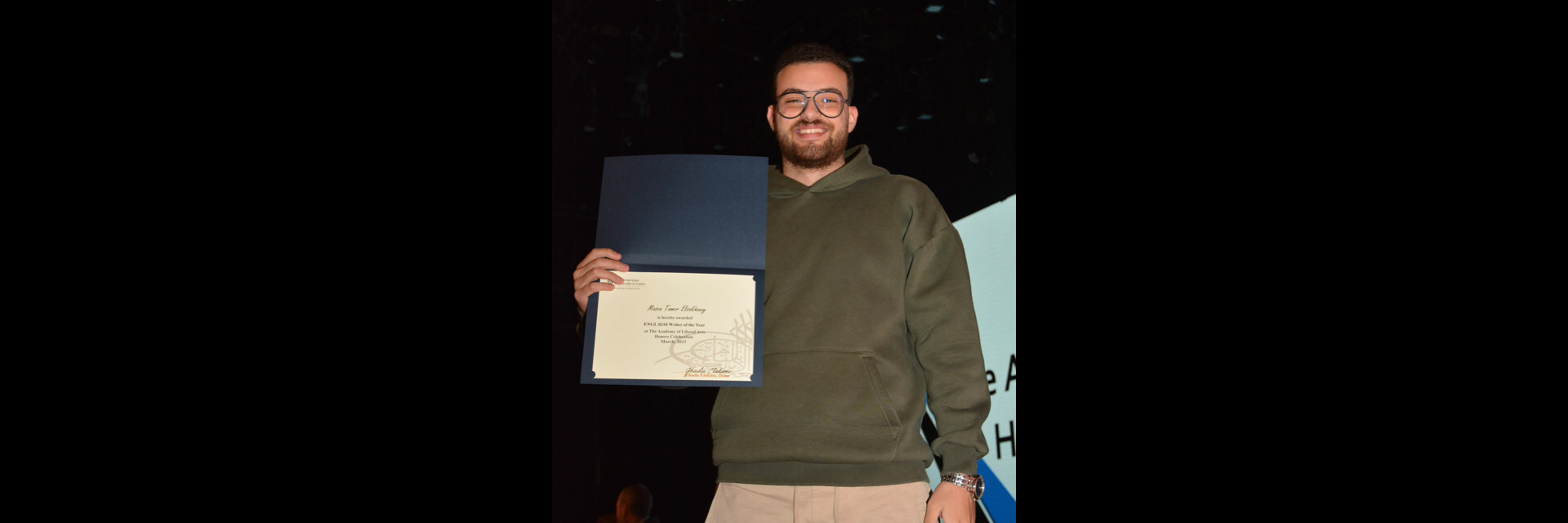 A picture of a student with their certificate of excellence 