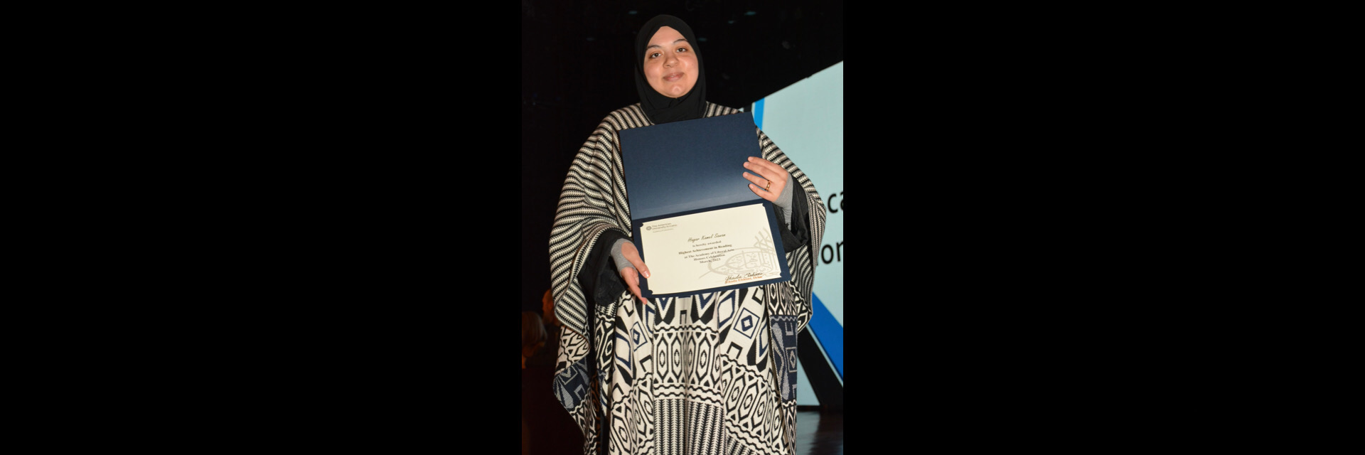 A picture of a student with their certificate of excellence 