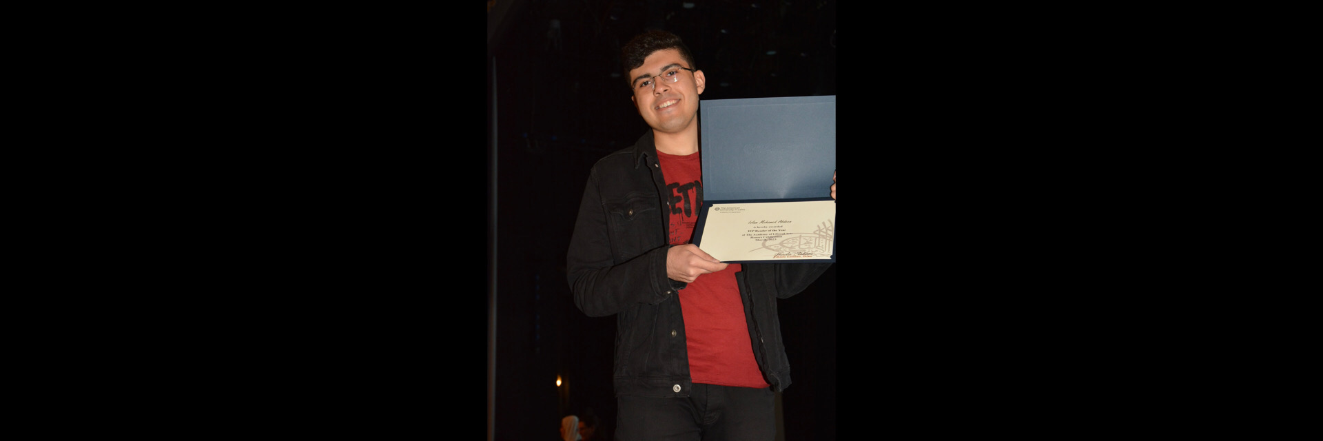 A picture of a student with their certificate of excellence 