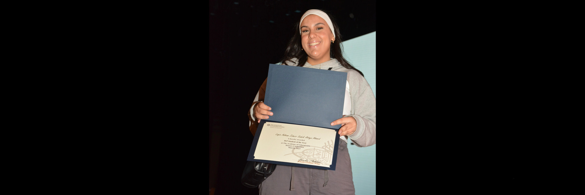 A picture of a student with their certificate of excellence 