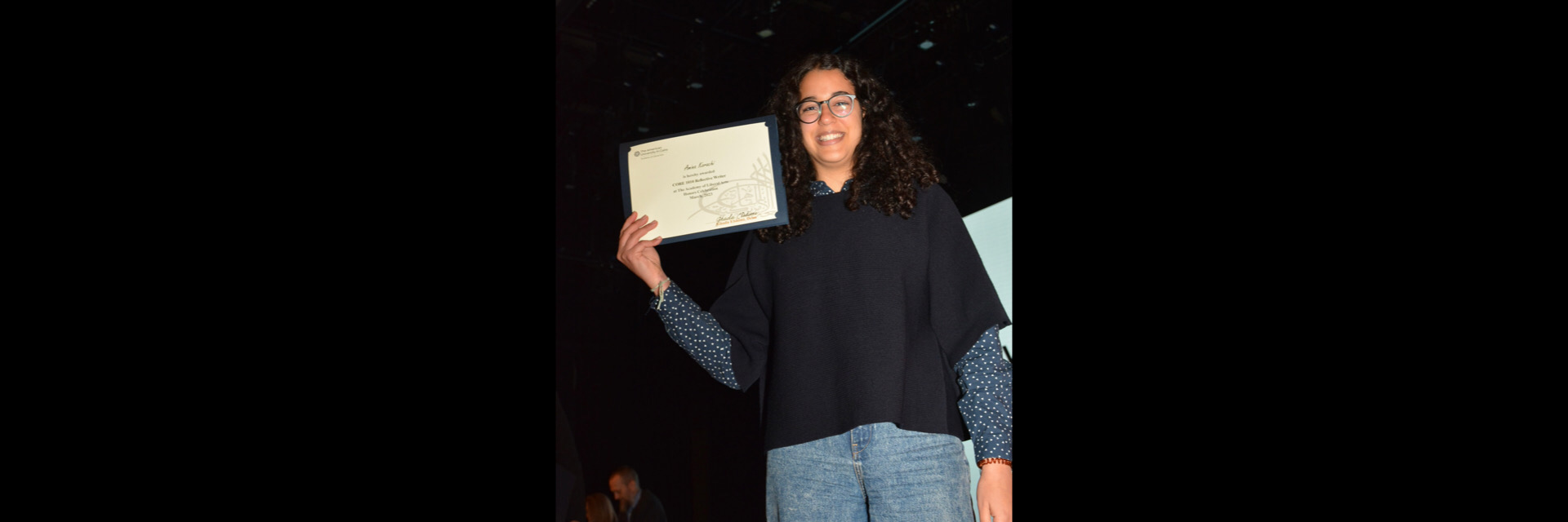 A picture of a student with their certificate of excellence 