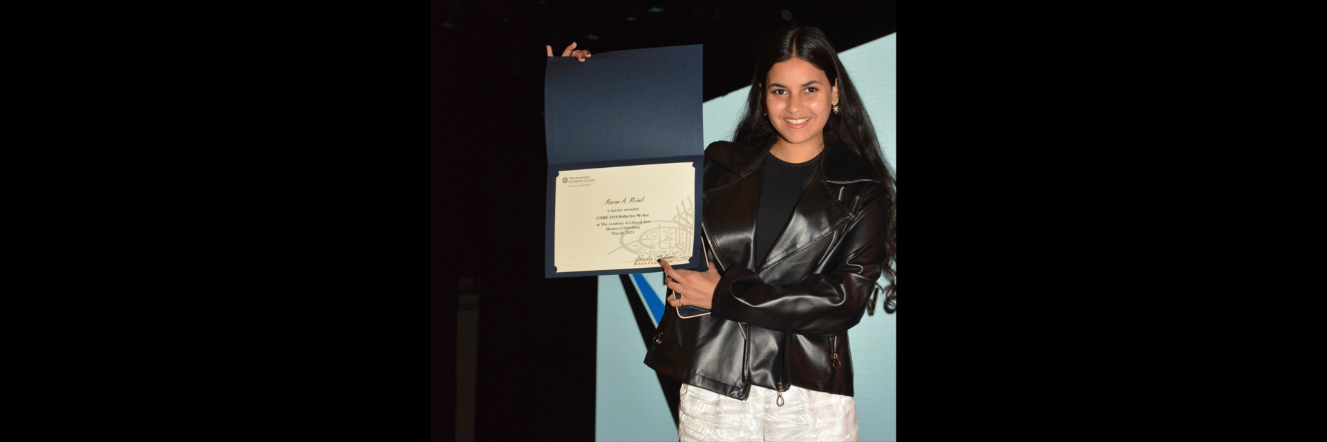 A picture of a student with their certificate of excellence 