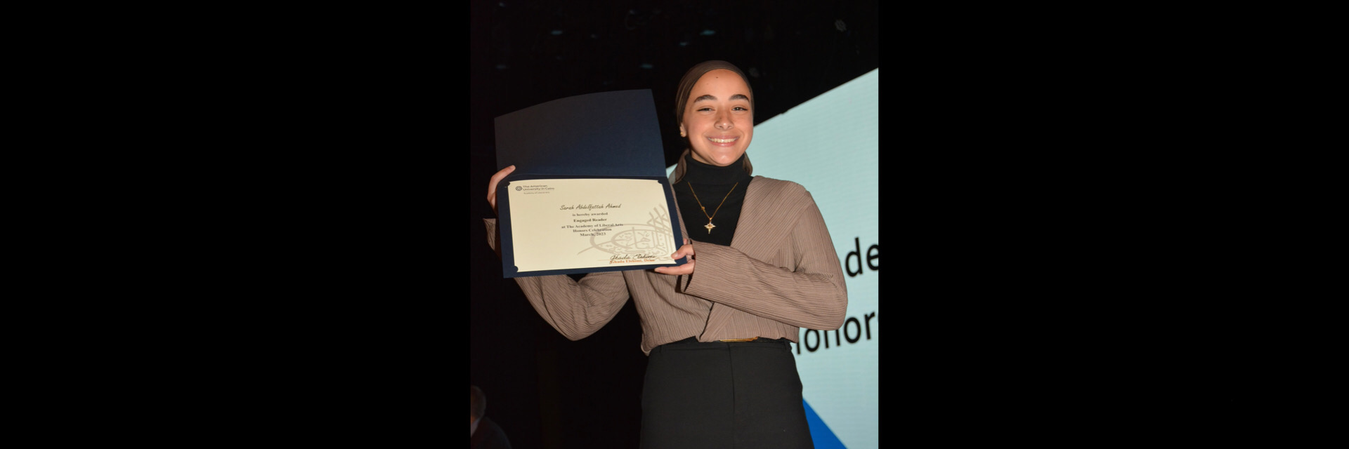 A picture of a student with their certificate of excellence 