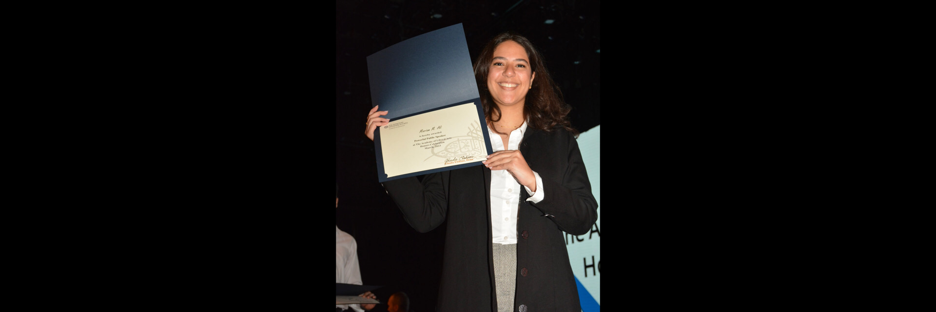 A picture of a student with their certificate of excellence 