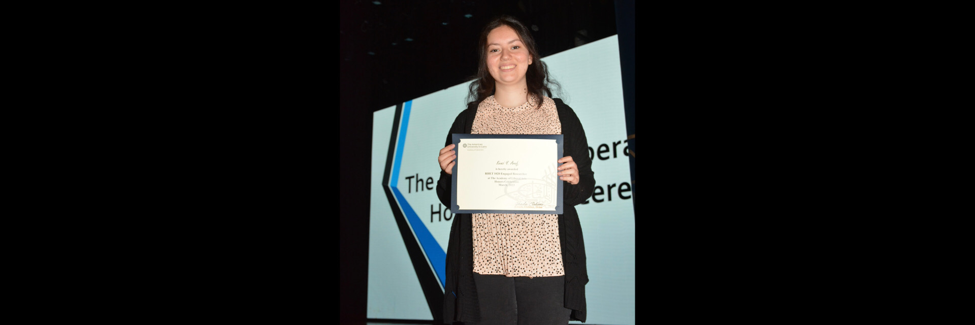 A picture of a student with their certificate of excellence 