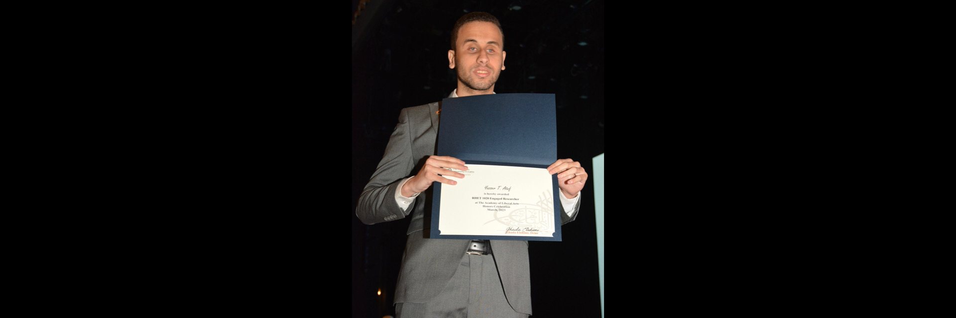 A picture of a student with their certificate of excellence 