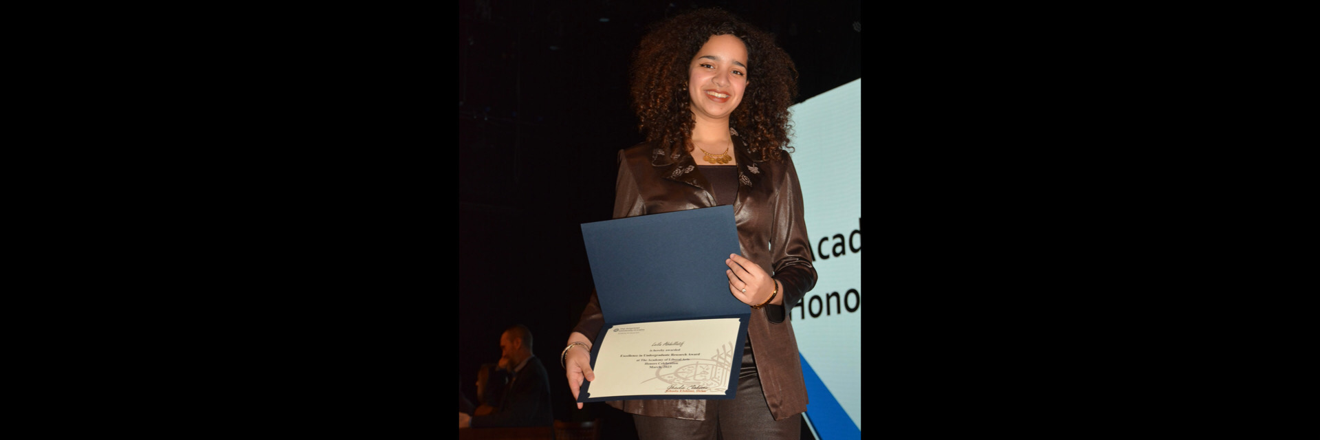 A picture of a student with their certificate of excellence 