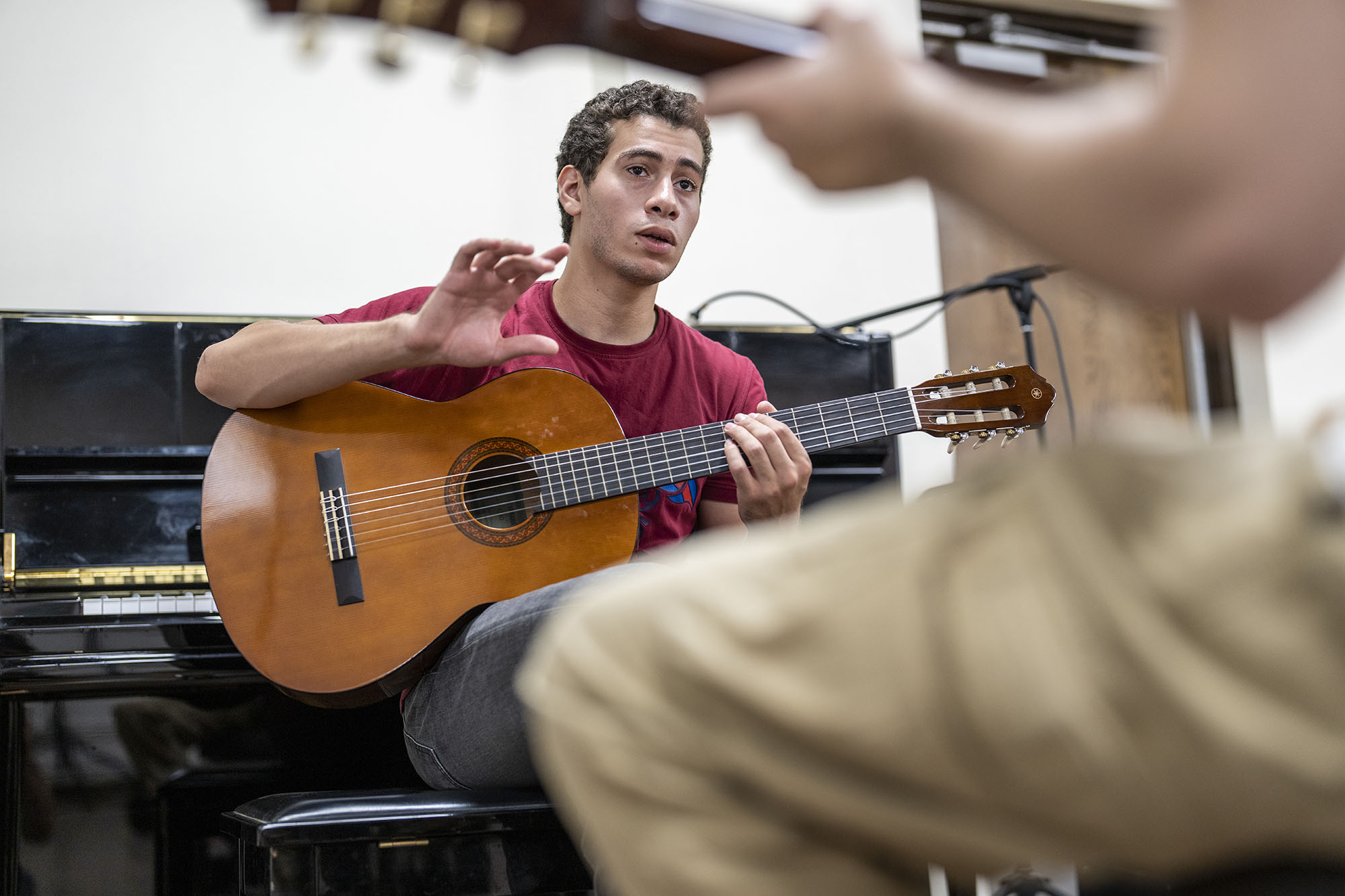 Two malae students holding guitars in music class