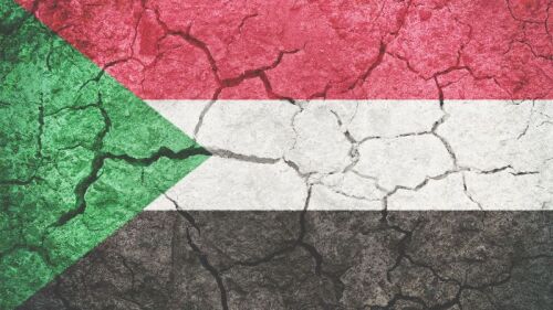 Sudan flag with cracks depicting conflict in the country