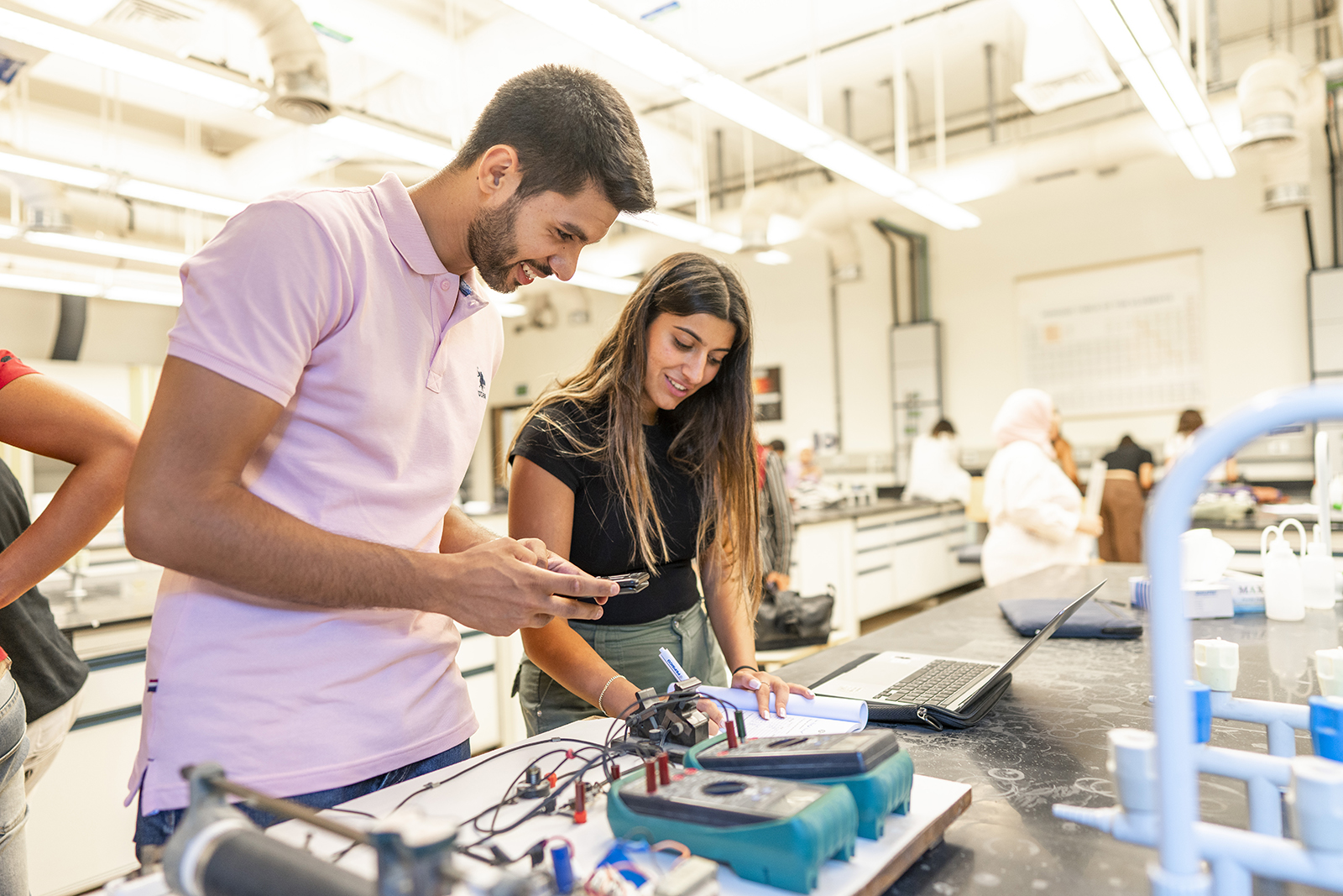 Girl and a boy working on an mechanical project in a lab