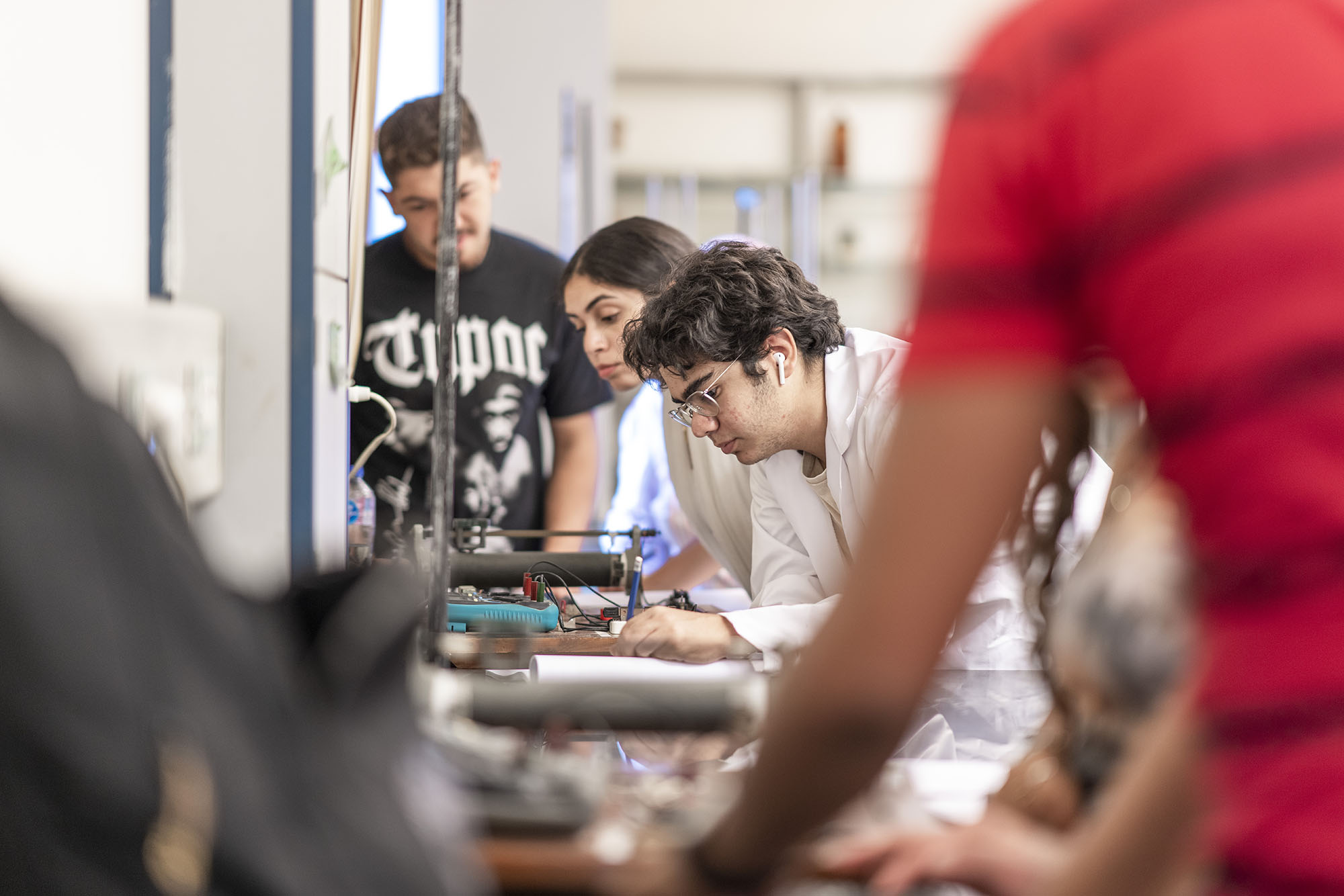 Students with lab coats working in labs