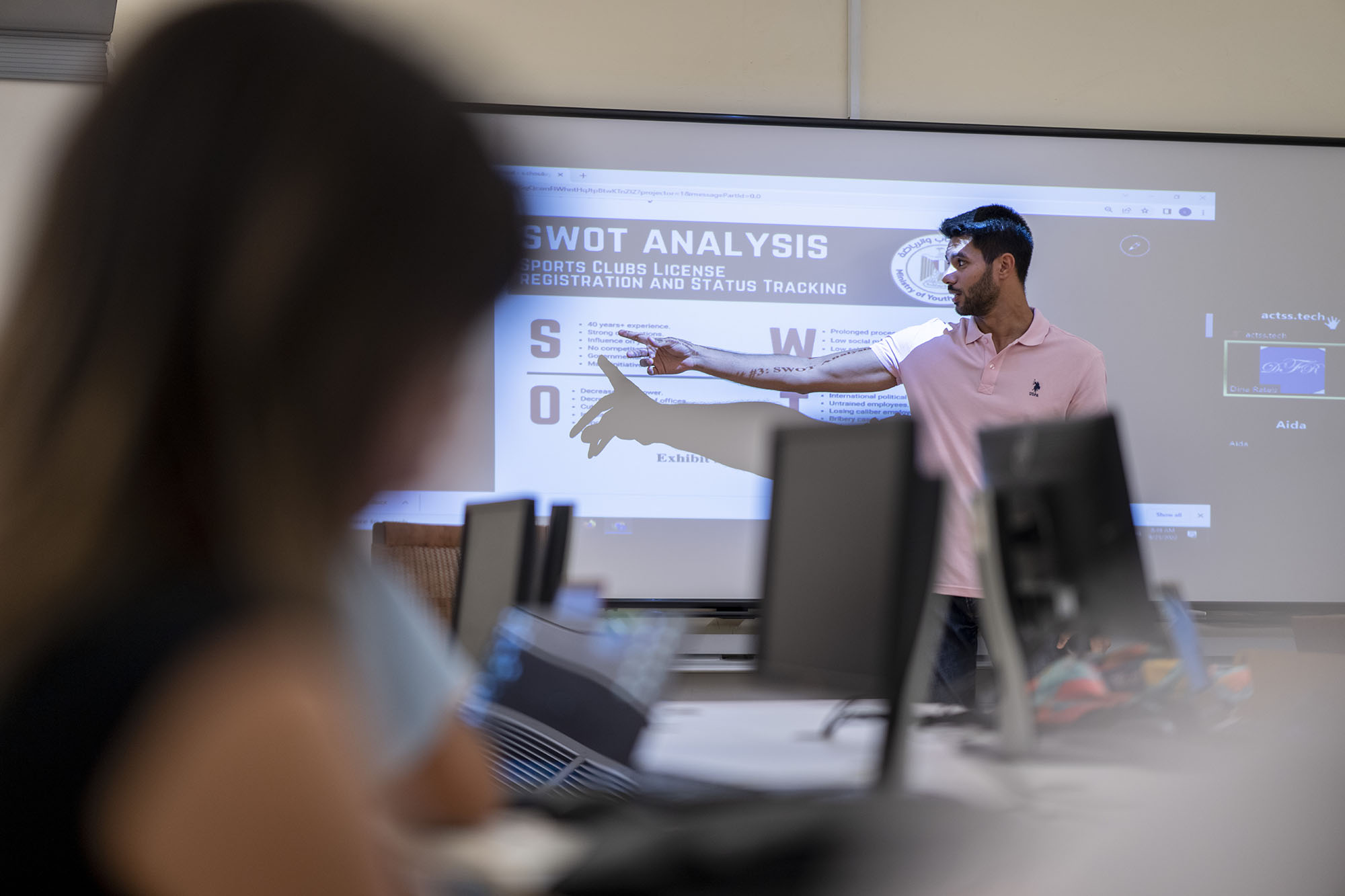 student in class presenting in front of other students on white board