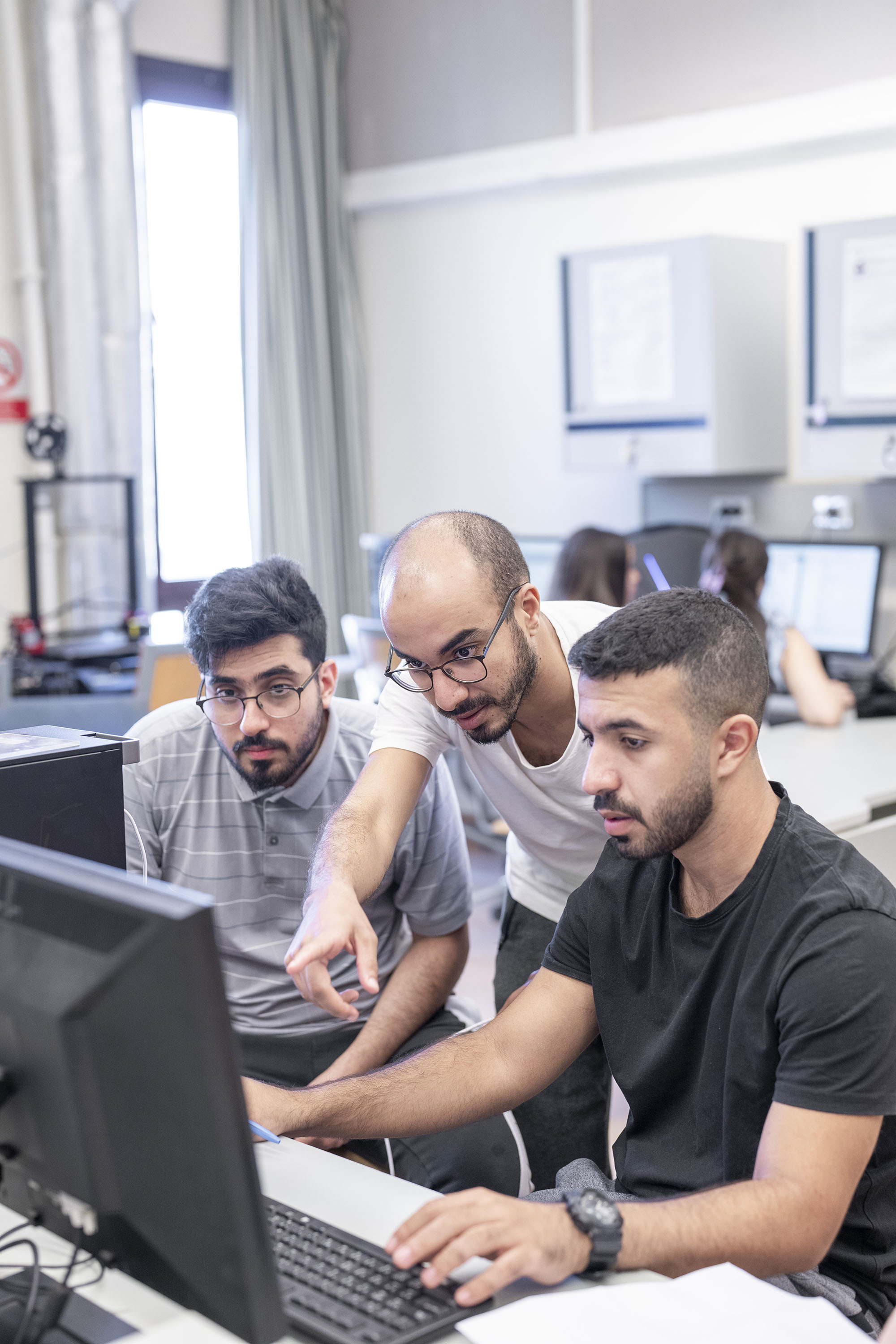 computer science program image with male students working on computers in a computer lab